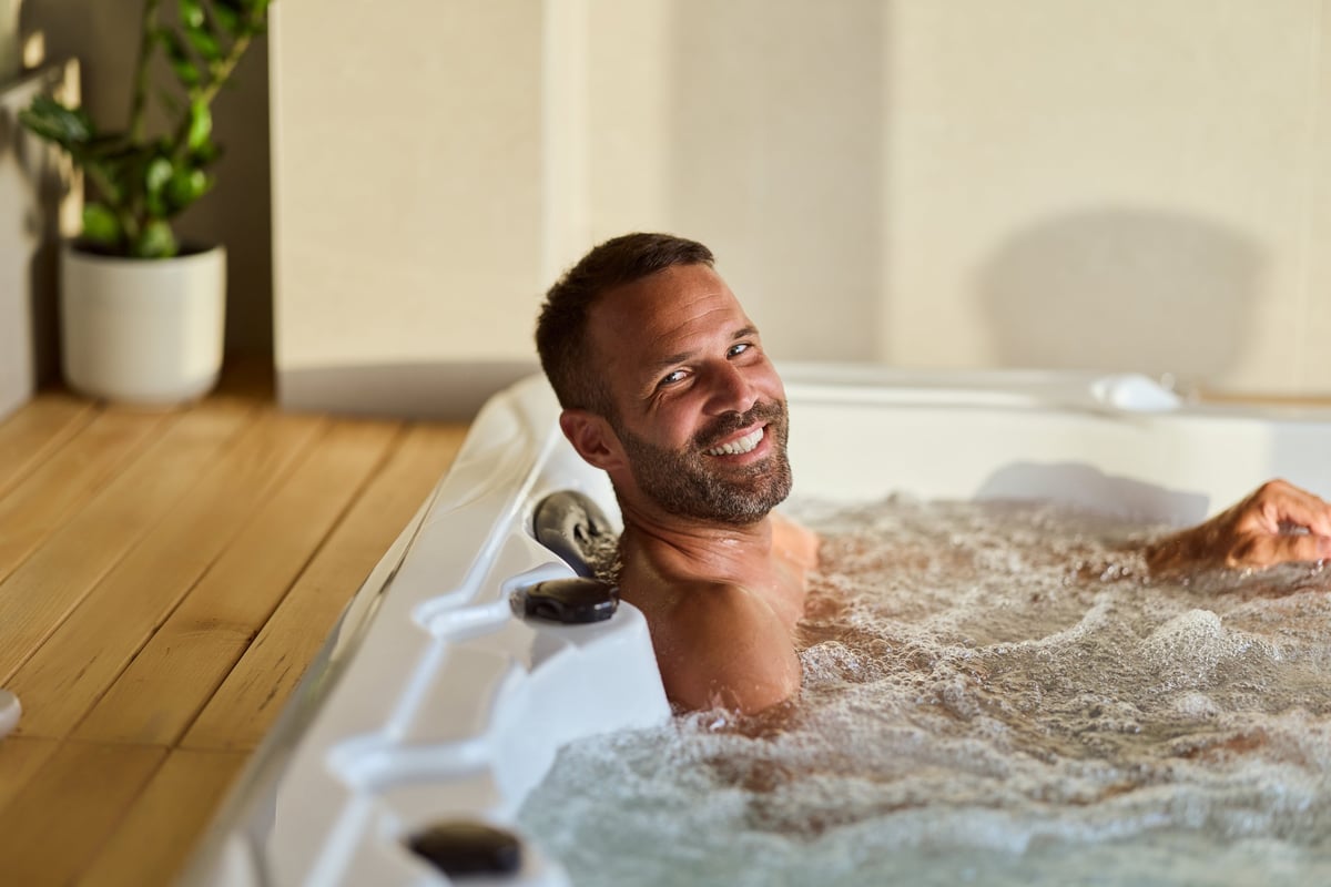 Man relaxing in a hydrotherapy tub filled with warm bubbling water