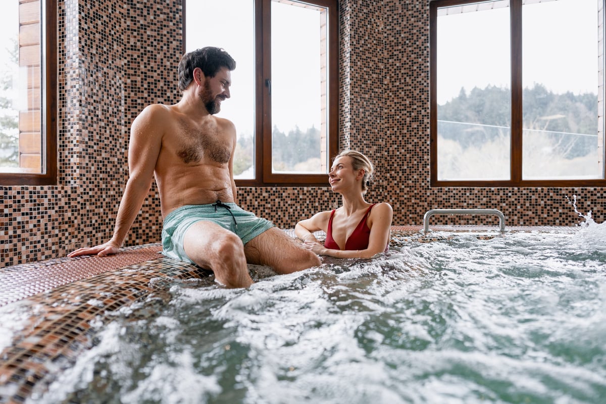 Smiling woman relaxing in a warm whirlpool bathtub